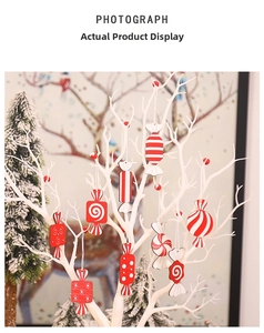Detail of red and white wood candy ornaments hanging on a white decorative branch