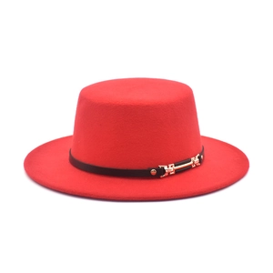 Detailed view of red wool felt boater hat with black leather band and gold buckle