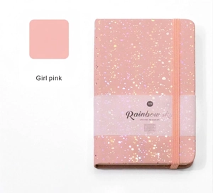 Detail of pink glitter hardcover notebook with elastic strap and Rainbow Sky sleeve
