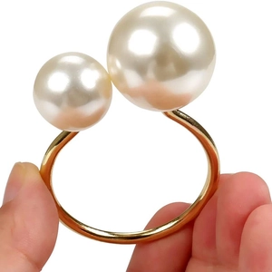 Elegant gold metal napkin ring featuring large and small pearls for table decoration
