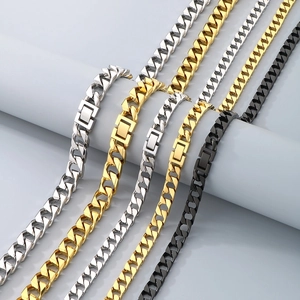 Detailed close-up of Cuban link chains in silver, gold, and black finishes on gray background