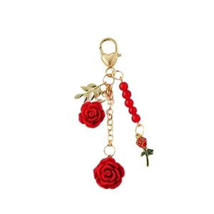 Romantic gold keychain with red resin roses and beads on a clean white background