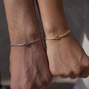 Couples stainless steel knot snake chains in gold and silver finish on hands