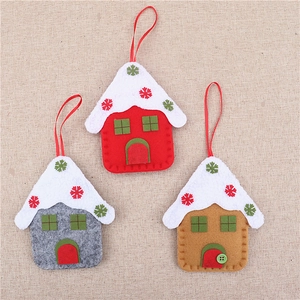 Detail of three felt Christmas house ornaments in red, gray, and brown with snowflake motifs