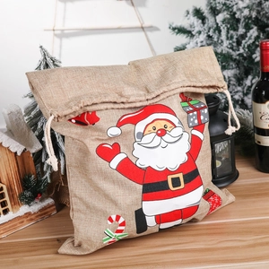 Festive Christmas burlap gift bag with Santa print and drawstring on a cozy wooden table