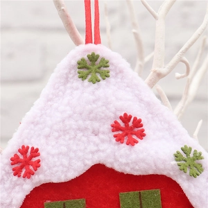 Macro shot of fabric Christmas house pendant with pink faux fur roof and snowflake detail