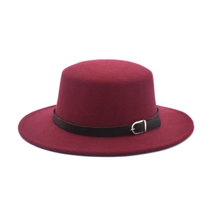 Detail of burgundy wool felt flat top hat with black belt and silver metal buckle accent