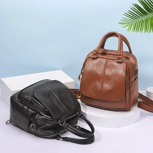Detail of vintage PU leather backpacks in black and brown on geometric platforms