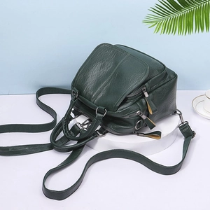 Detail of dark green PU leather bag showing vintage wrinkled texture and metal zippers