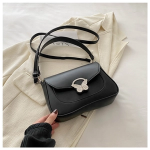 Minimalist black leather underarm bag with a silver butterfly metal clasp and long strap