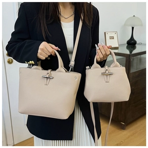 Comparison of small and large beige leather bamboo buckle bags shown on a model