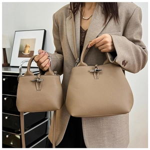 Detailed comparison of mini and small tan pebble leather bamboo handle bags on a model