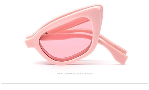 Detail view of pink cat-eye sunglasses in a compact folded state on white background
