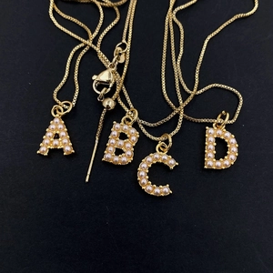 Gold plated initial necklaces A-D with inlaid pearls on a minimalist box chain