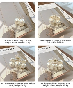 Detail of faux pearl hair claws in four sizes displayed on creative miniature swings