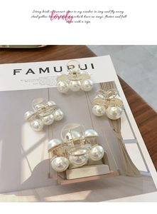 Detail of elegant pearl hair claws in various sizes on a minimalist aesthetic background
