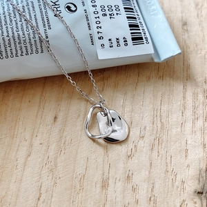 Macro detail of overlapping silver geometric irregular pendants on a delicate chain