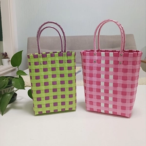 Detailed view of handmade woven bucket bags featuring colorful plaid patterns and handles