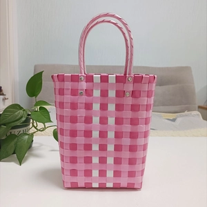 Close-up of pink and white handmade woven bucket bag with durable transparent tube handles