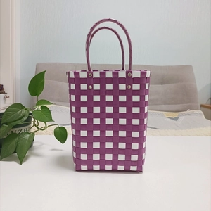 Detailed view of handmade purple and white checkered woven basket with sturdy handles