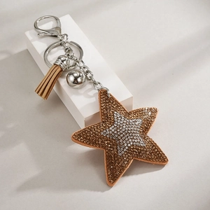 Star-shaped rhinestone keychain with brown and silver leather tassels on white pedestal