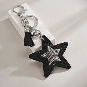 Detailed view of a black rhinestone star keychain with velvet tassels and metal hardware