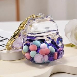 Macro view of transparent lucky cat keychain with purple liquid and colored beads