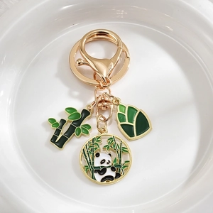 Cute panda and bamboo metal keychain with gold finish and green enamel pendants