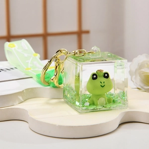 Detail of frog oil liquid keychain with gold clip and green floral strap