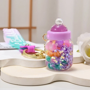 Luminous milk bottle keychain with colorful beads and purple bubble strap on white stand