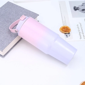 Close-up of a 30oz gradient pink and purple tumbler with handle and straw in lifestyle setting