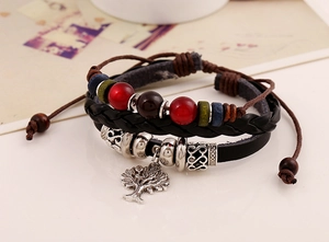 Detailed close-up of braided leather bracelet featuring silver Tree of Life charm and beads