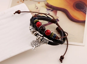 Close-up of woven leather bracelet with colorful beads and silver Tree of Life charm