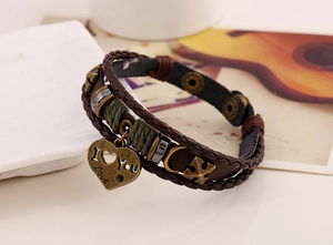 Close-up of brown leather braided bracelet with I Love You heart and anchor charms