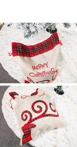 Close-up of linen Christmas gift bag with red drawstring and Merry Christmas print