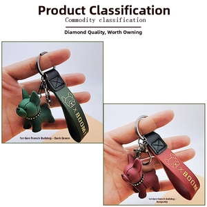 Detail of French Bulldog keychains in dark green and burgundy with leather wrist straps