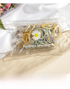 Detail of colorful elastic hair bands in a daisy zipper bag with decorative flowers