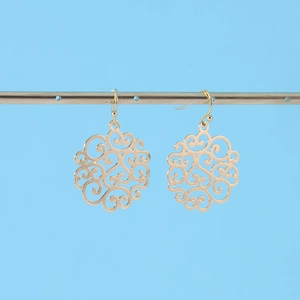 Detail of rose gold filigree drop earrings with hollow scroll pattern on a metal stand