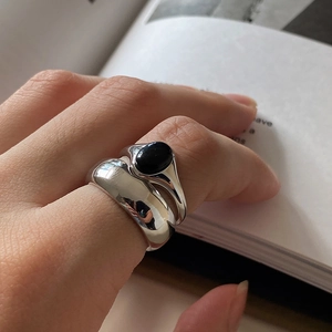 925 Sterling silver ring set with black onyx gemstone worn on fingers over a book