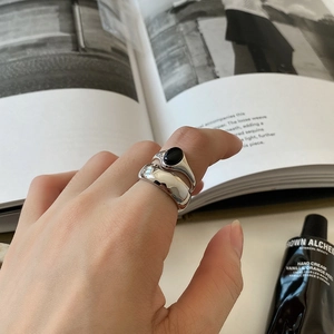 Close-up of minimalist silver rings for couples featuring a black onyx gemstone inlay