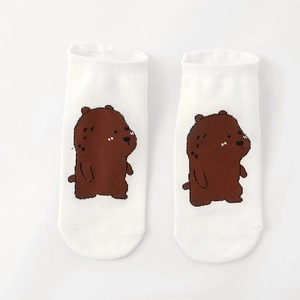 Detailed view of white cotton socks with cute brown bear cartoons on plain background