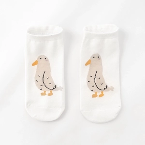 Detail of white cotton socks featuring a cute cartoon seagull pattern on a clean background