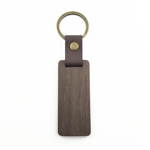 Detail of dark walnut wood keychain with brown leather strap and brass metal ring