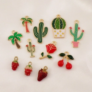 Assorted DIY enamel charms set featuring palm trees, cacti, and colorful fruits on fabric