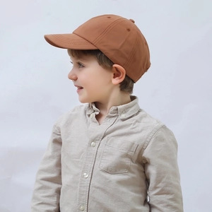 Classic brown kids baseball cap in plain cotton shown from a stylish side view angle