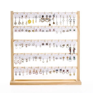 Five-tier wooden earring display stand organized with various stud and drop earrings