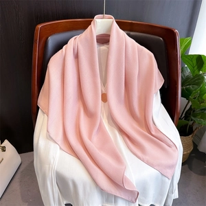 Pink vintage cotton linen scarf draped on a white shirt in a cozy indoor setting