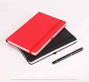Detail view of red and black hardcover notebooks with elastic straps and a fountain pen