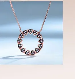 Macro detail of rose gold pendant necklace with rainbow topaz stones on gradient background