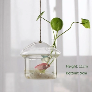 Macro view of mushroom-shaped hanging glass vase with water, pebbles and small fish inside